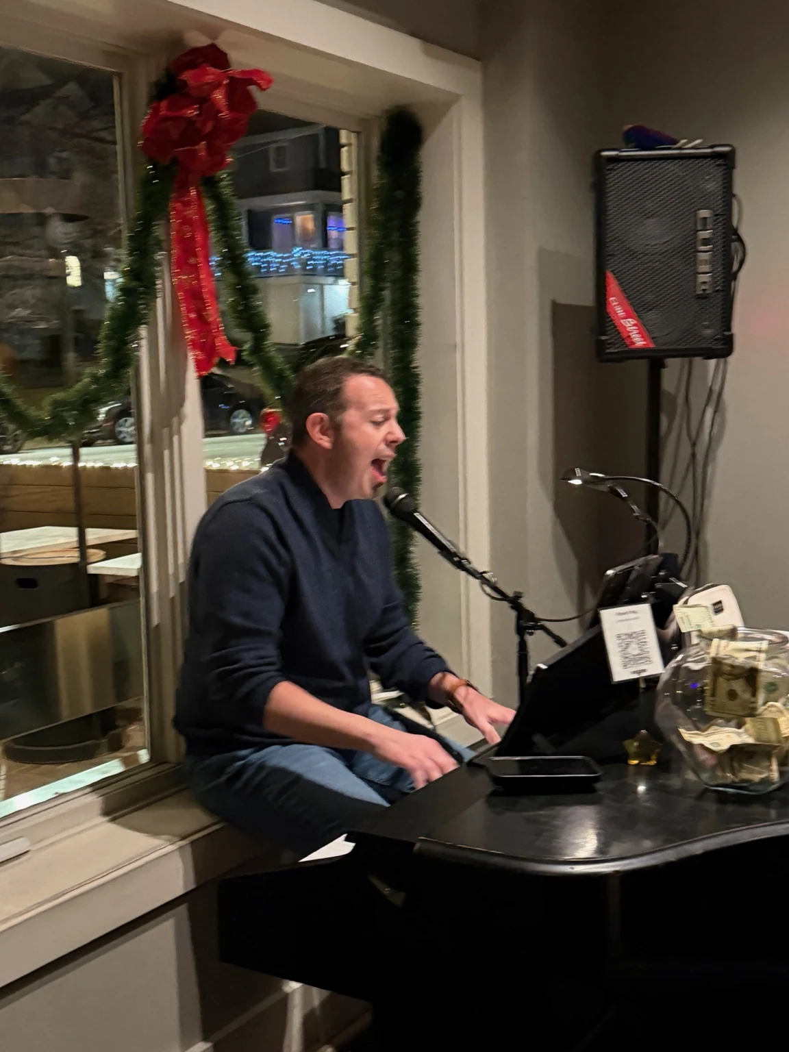 Daniel singing and playing piano at a venue